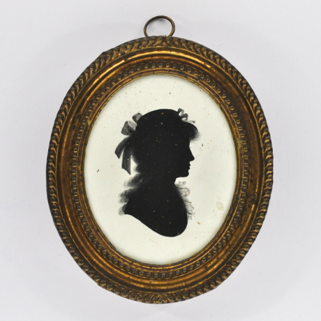 
        Front of silhouette, in frame, with woman looking right, wearing a hat with ribbons.