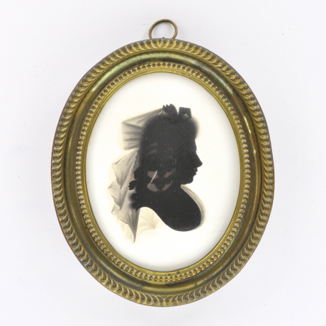 
        Front of silhouette, in frame, with woman looking right, wearing a hat with ribbons.