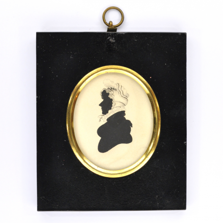 Front of silhouette, in frame, with woman looking left, wearing a bonnet.